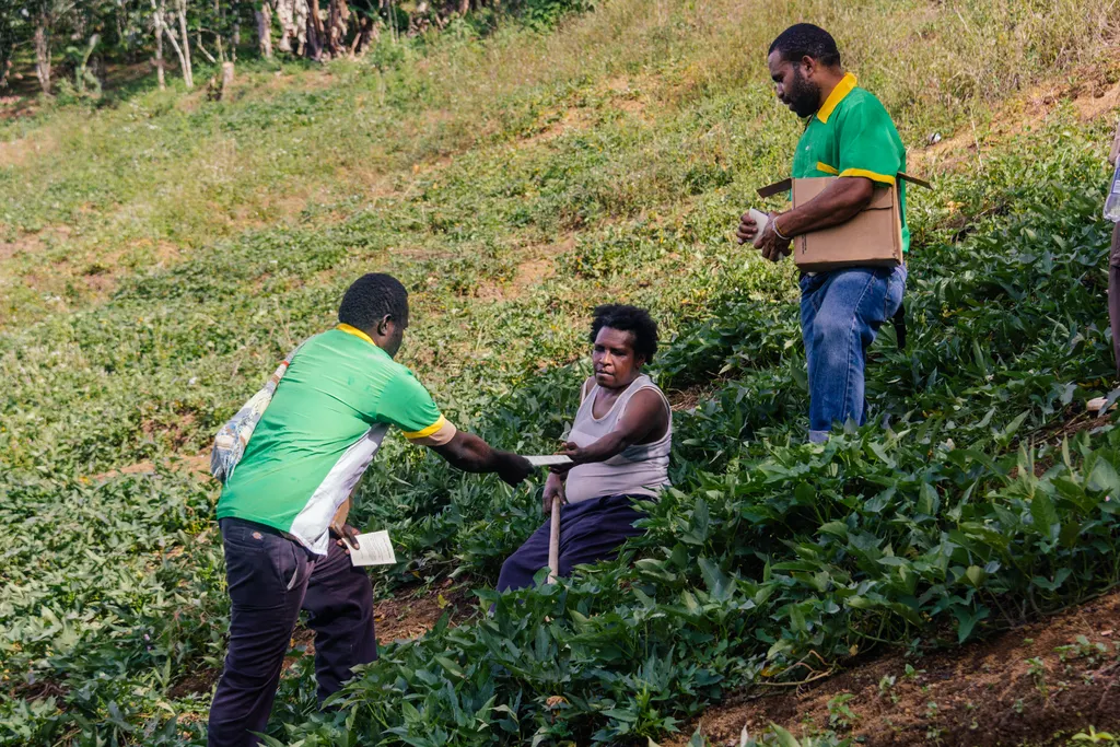 Every Home workers sharing gospel literature with a woman in her hillside garden